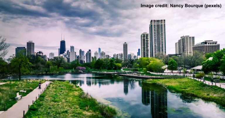 River Near City Buildings Under Cloudy Sky