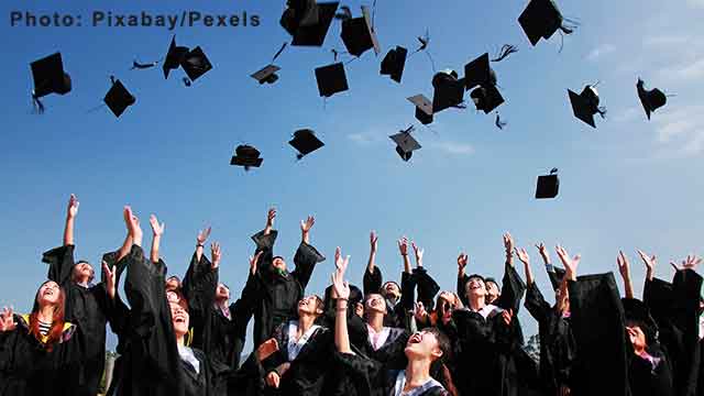 Newly Graduated People Wearing Black Academy Gowns Throwing Hats Up in the Air