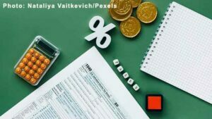 Tax Documents, calculator, notepad and coins on the Table